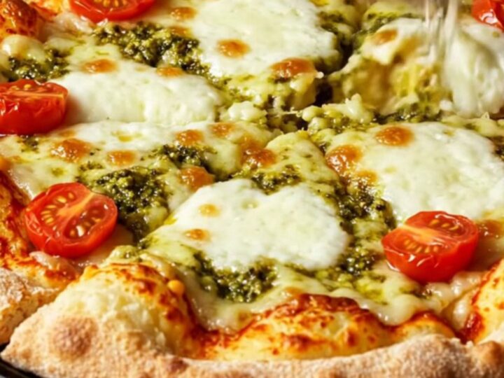 A close-up of a crispy smashed potato pizza with golden cheese and fresh toppings.