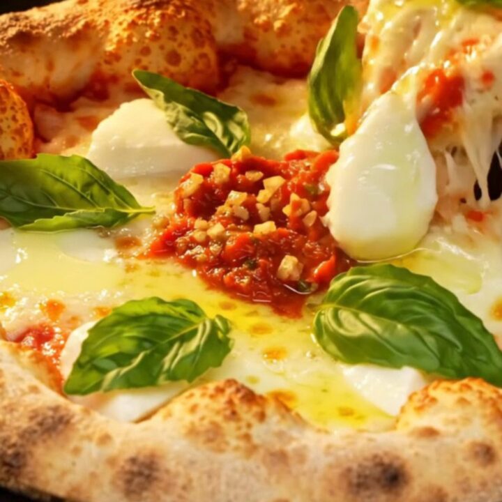 A crispy, square-cut Sicilian Grandma-style pizza with a golden, fried crust, melted mozzarella, and fresh basil leaves.