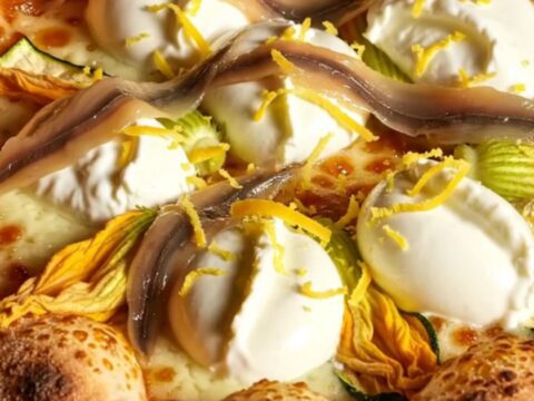 A close-up of a Roman pizza bianca with zucchini blossoms and creamy cheese, showing a perfect airy crust.