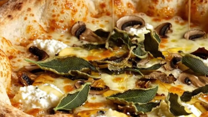 A close-up of a truffle ricotta stuffed crust pizza with mushrooms, melted fontina, and a drizzle of honey.