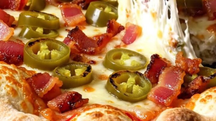 A close-up of a stuffed crust pizza with a molten cream cheese and jalapeño filling being pulled apart.