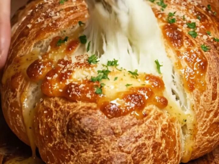A braided chicken alfredo pizza loaf sliced open to reveal creamy filling.