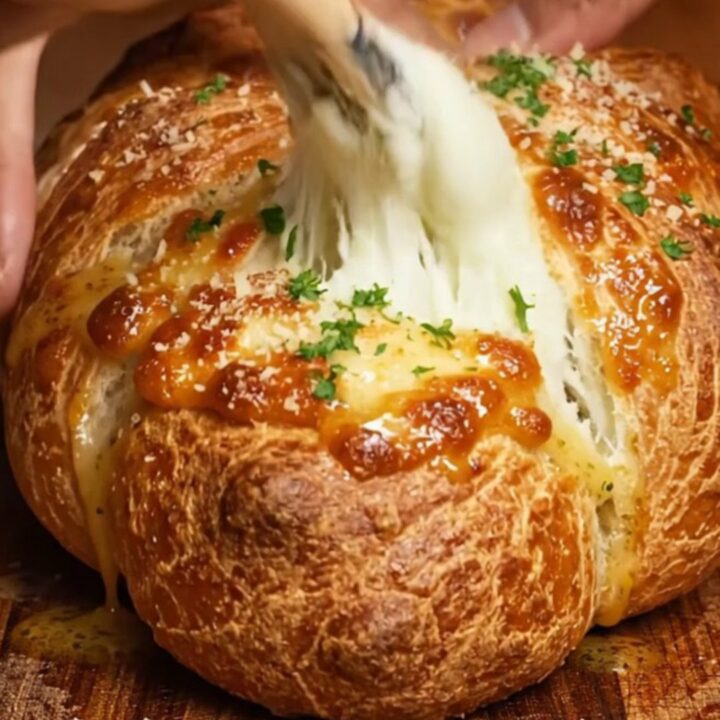 A braided chicken alfredo pizza loaf sliced open to reveal creamy filling.