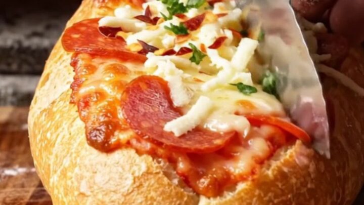 A crispy, golden-brown stuffed pizza baguette boat sliced into thick rounds with melted mozzarella and pepperoni.