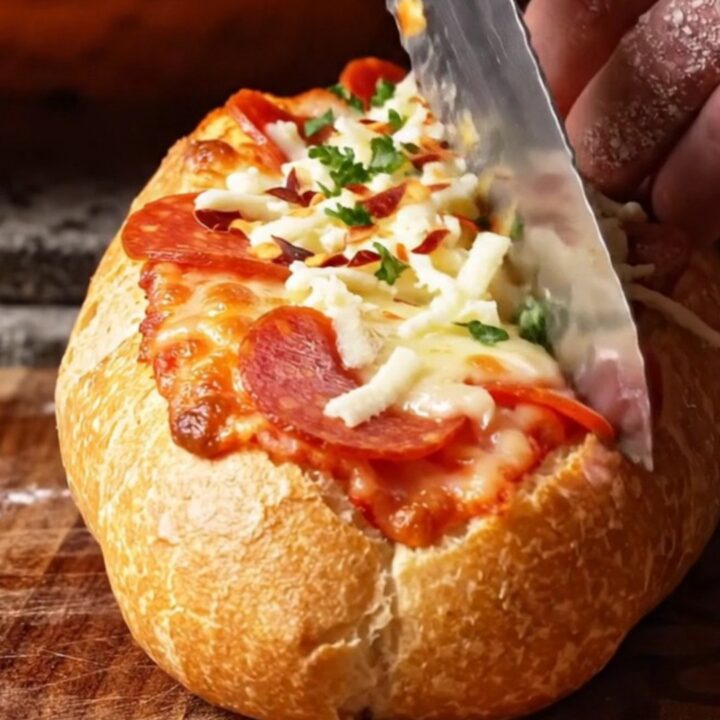 A crispy, golden-brown stuffed pizza baguette boat sliced into thick rounds with melted mozzarella and pepperoni.