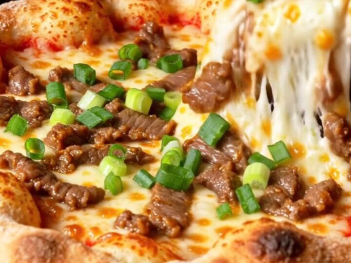 A slice of Korean corn-cheese stuffed crust pizza being lifted, showing stretchy mozzarella and sweet corn.