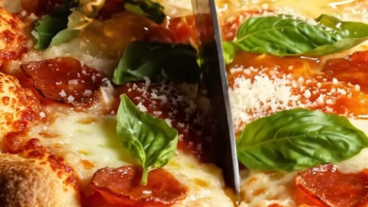 A close-up shot of a thick square of pepperoni pizza focaccia with a golden, bubbly crust and melted cheese.
