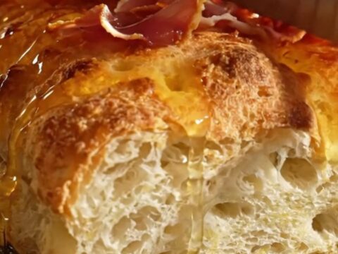 A golden, dimpled focaccia topped with creamy ricotta, green asparagus, and crispy prosciutto ribbons.