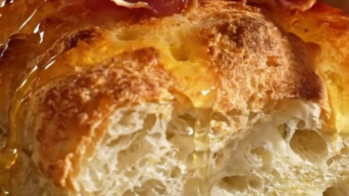 A golden, dimpled focaccia topped with creamy ricotta, green asparagus, and crispy prosciutto ribbons.