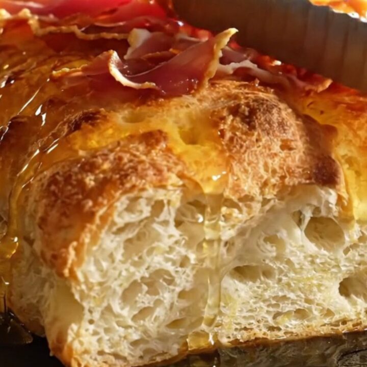 A golden, dimpled focaccia topped with creamy ricotta, green asparagus, and crispy prosciutto ribbons.