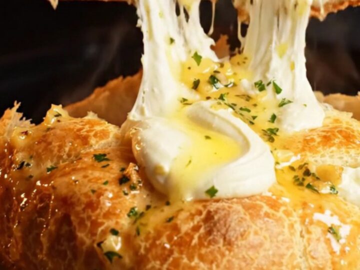 A golden brown cheesy garlic focaccia bread cut into diamond shapes with cream cheese oozing out.