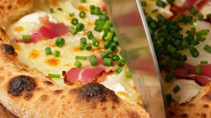A crispy, paper-thin Alsatian Tarte Flambée topped with smoky bacon lardons and fresh chives
