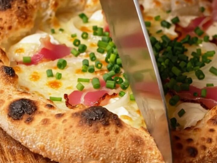 A crispy, paper-thin Alsatian Tarte Flambée topped with smoky bacon lardons and fresh chives