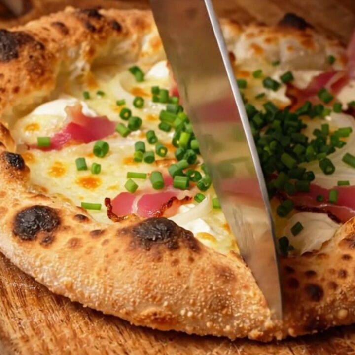 A crispy, paper-thin Alsatian Tarte Flambée topped with smoky bacon lardons and fresh chives