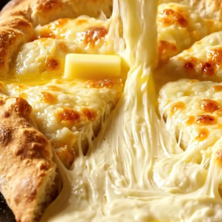 A golden-brown Imeruli Khachapuri sliced into wedges with molten cheese oozing from the center.