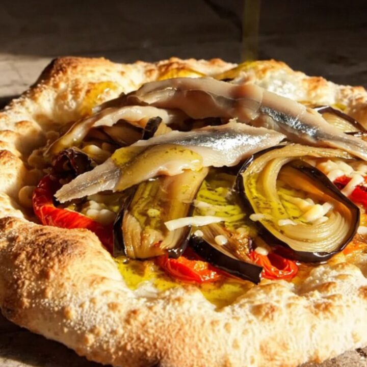 A rustic, crispy Catalan Coca flatbread topped with roasted red peppers, charred eggplant, and anchovies.