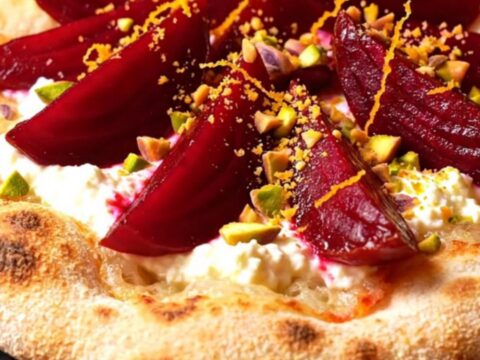 A crispy za'atar flatbread topped with swirls of whipped goat cheese and roasted beet wedges