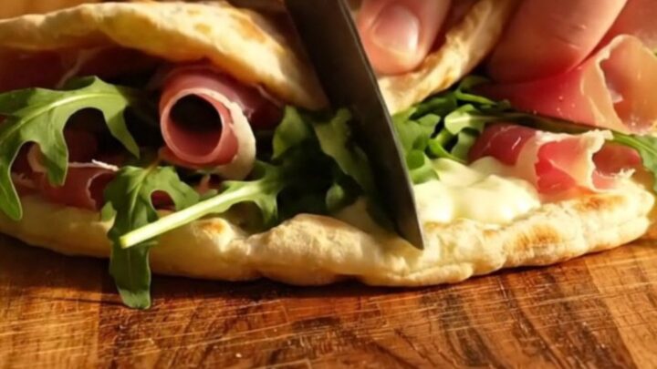 A warm Romagna-style Piadina folded with melted squacquerone cheese, prosciutto crudo, and fresh wild rocket.