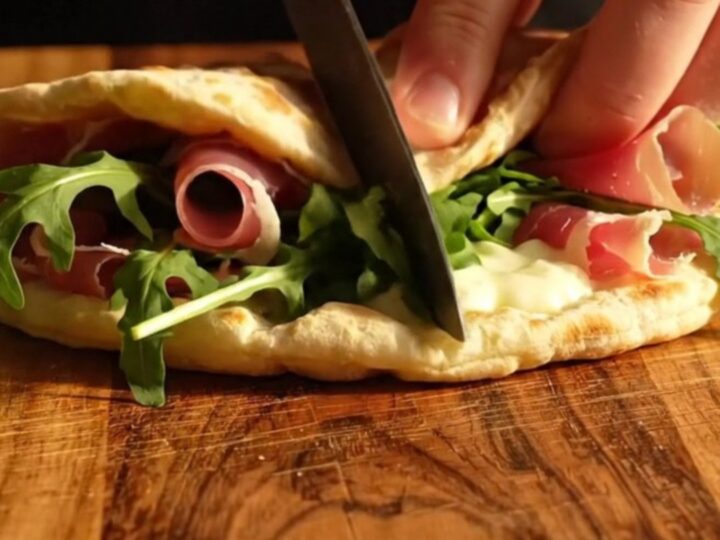 A warm Romagna-style Piadina folded with melted squacquerone cheese, prosciutto crudo, and fresh wild rocket.