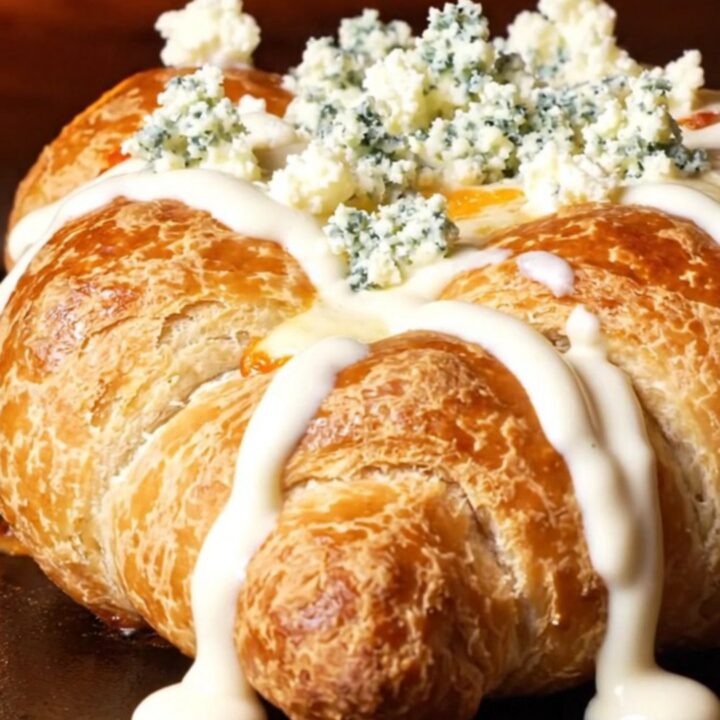 A close-up view of a spicy buffalo chicken calzone sliced in half, showing a gooey, cheesy interior.