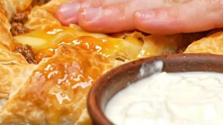 A golden, spiraled Bosnian Burek resting in a cast-iron skillet, showing crispy, flaky layers.