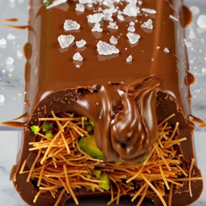 A close-up of a broken Dubai pistachio chocolate bar showing the bright green filling.