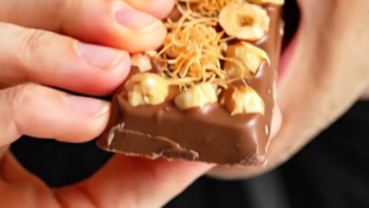 A close-up shot of a broken Gianduja and kataifi chocolate bar showing the creamy hazelnut interior.