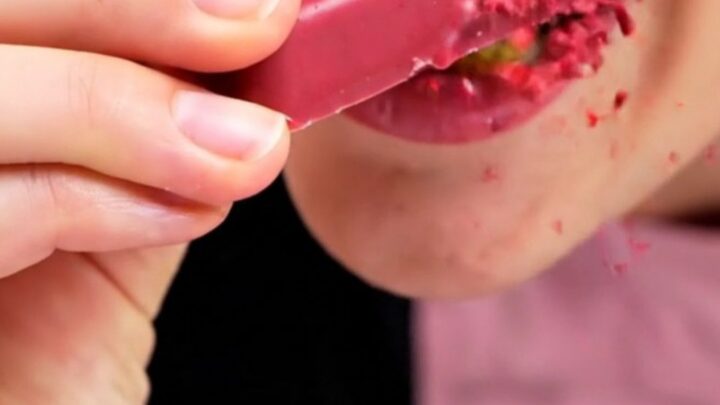 A close-up shot of a ruby chocolate bar snapped in half, showing the crispy kataifi and raspberry filling.