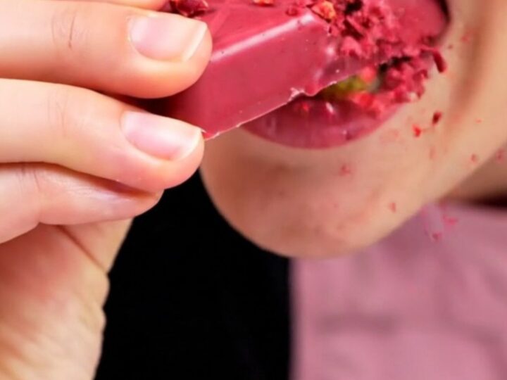 A close-up shot of a ruby chocolate bar snapped in half, showing the crispy kataifi and raspberry filling.