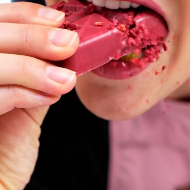 A close-up shot of a ruby chocolate bar snapped in half, showing the crispy kataifi and raspberry filling.