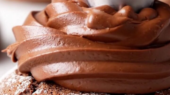 A close-up view of a chilled double fudge cookie, cut in half to show the dense chocolate base and the thick