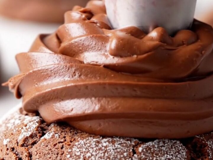 A close-up view of a chilled double fudge cookie, cut in half to show the dense chocolate base and the thick