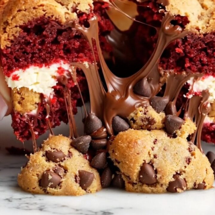 Extreme close-up of a three-toned brookie bar showing red velvet brownie, cheesecake swirl, and cookie dough.