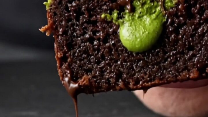 A close-up of a square matcha white chocolate brownie showing a vibrant green swirl on dark chocolate.