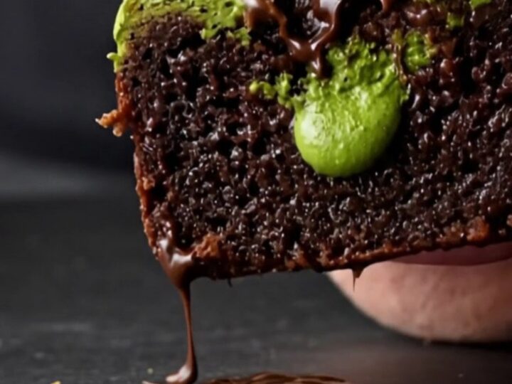 A close-up of a square matcha white chocolate brownie showing a vibrant green swirl on dark chocolate.