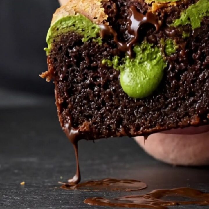 A close-up of a square matcha white chocolate brownie showing a vibrant green swirl on dark chocolate.