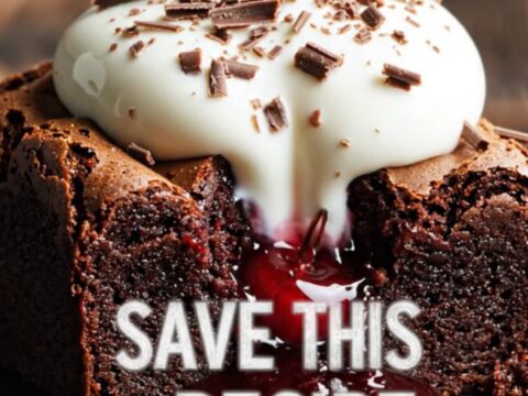 A close-up of a fork breaking into a fudgy dark chocolate brownie with visible cherry pockets and mascarpone cream.