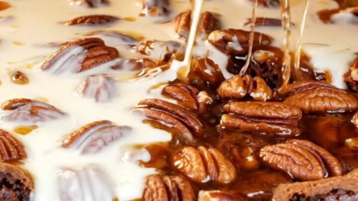 A close-up of a decadent brookie with a dark brownie base and a gooey, glossy bourbon pecan pie topping.