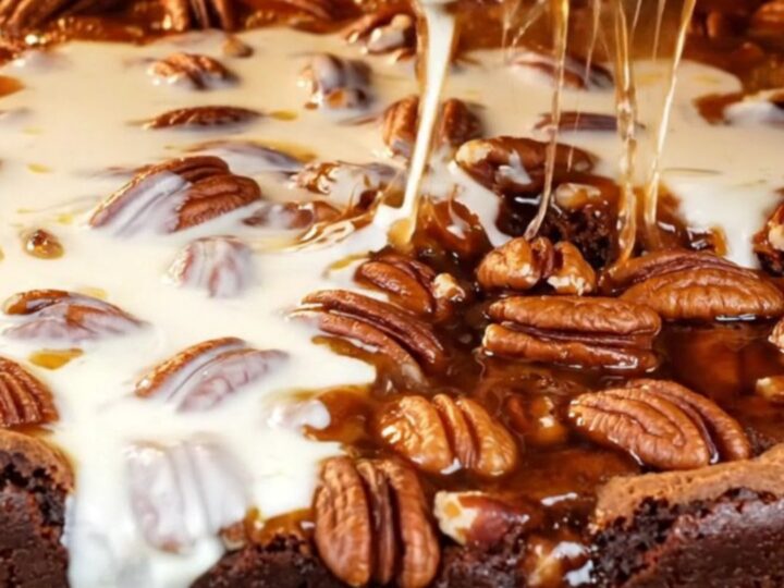 A close-up of a decadent brookie with a dark brownie base and a gooey, glossy bourbon pecan pie topping.