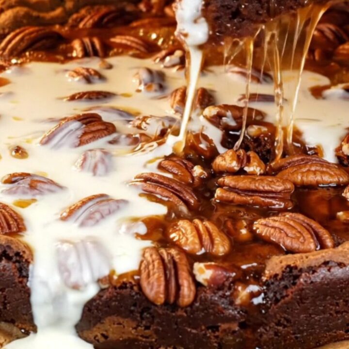 A close-up of a decadent brookie with a dark brownie base and a gooey, glossy bourbon pecan pie topping.