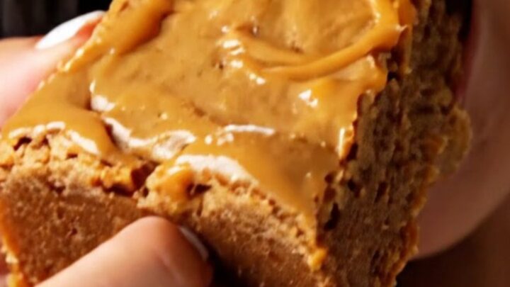 A stack of thick, golden-brown blondies with a shiny, crackly top, showing melted butterscotch and bits of toffee inside.