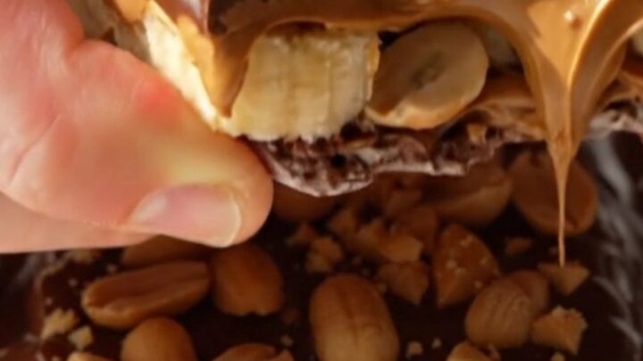 A close-up of frozen banana bark shards showing layers of banana, peanut butter, and dark chocolate.
