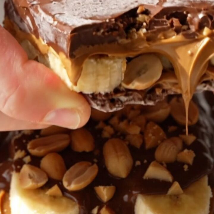 A close-up of frozen banana bark shards showing layers of banana, peanut butter, and dark chocolate.