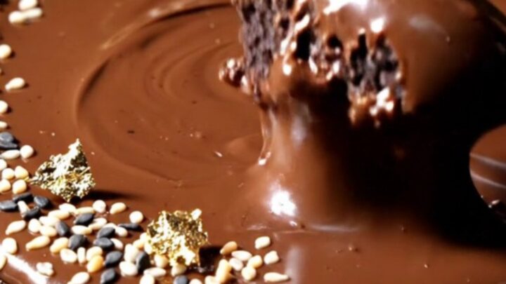Extreme close-up of a slice being cut from a black sesame tart with a visible dark chocolate ganache layer.