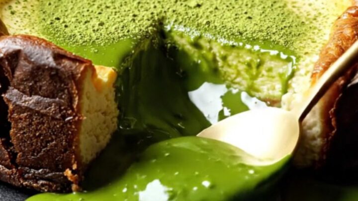 A close-up of a molten Uji matcha Basque cheesecake with a deeply charred top and a flowing emerald center.