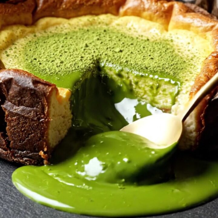 A close-up of a molten Uji matcha Basque cheesecake with a deeply charred top and a flowing emerald center.