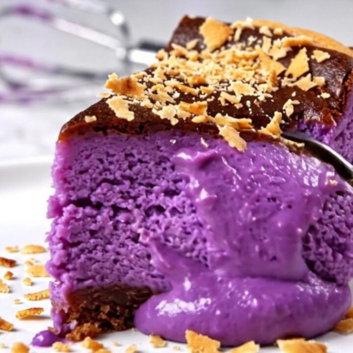 A vibrant purple Ube Basque cheesecake with a perfectly charred, dark bronze crust sitting on a modern kitchen counter.