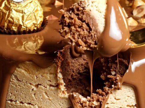 A close-up of a Nutella cheesecake topped with Ferrero Rocher truffles and toasted hazelnuts.