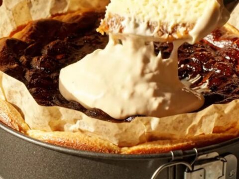 A slice of golden-brown pumpkin Basque cheesecake on a vintage ceramic plate with a dollop of cream.