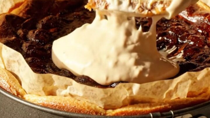 A slice of golden-brown pumpkin Basque cheesecake on a vintage ceramic plate with a dollop of cream.